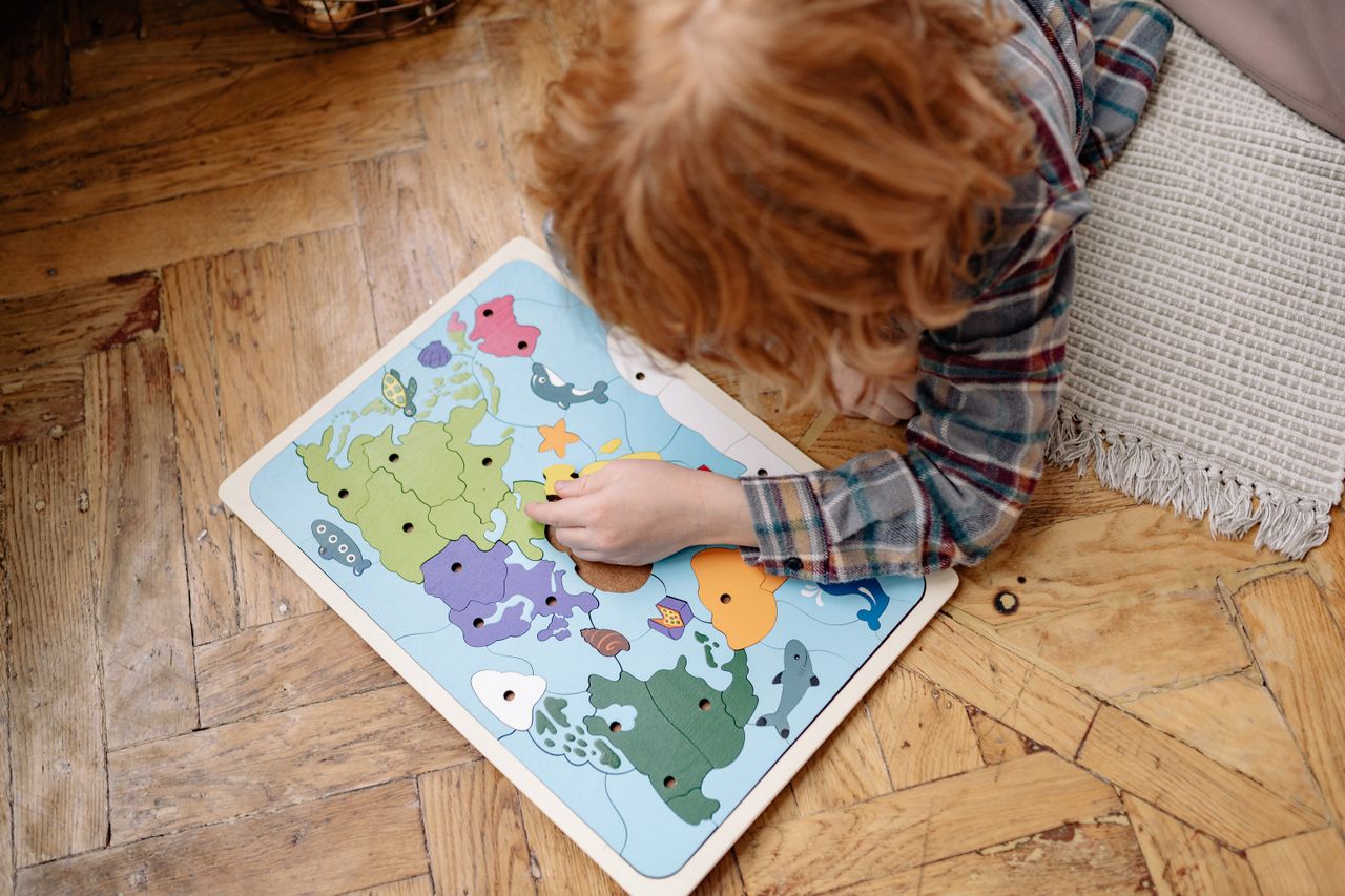 A child exploring geography through a Montessori puzzle map