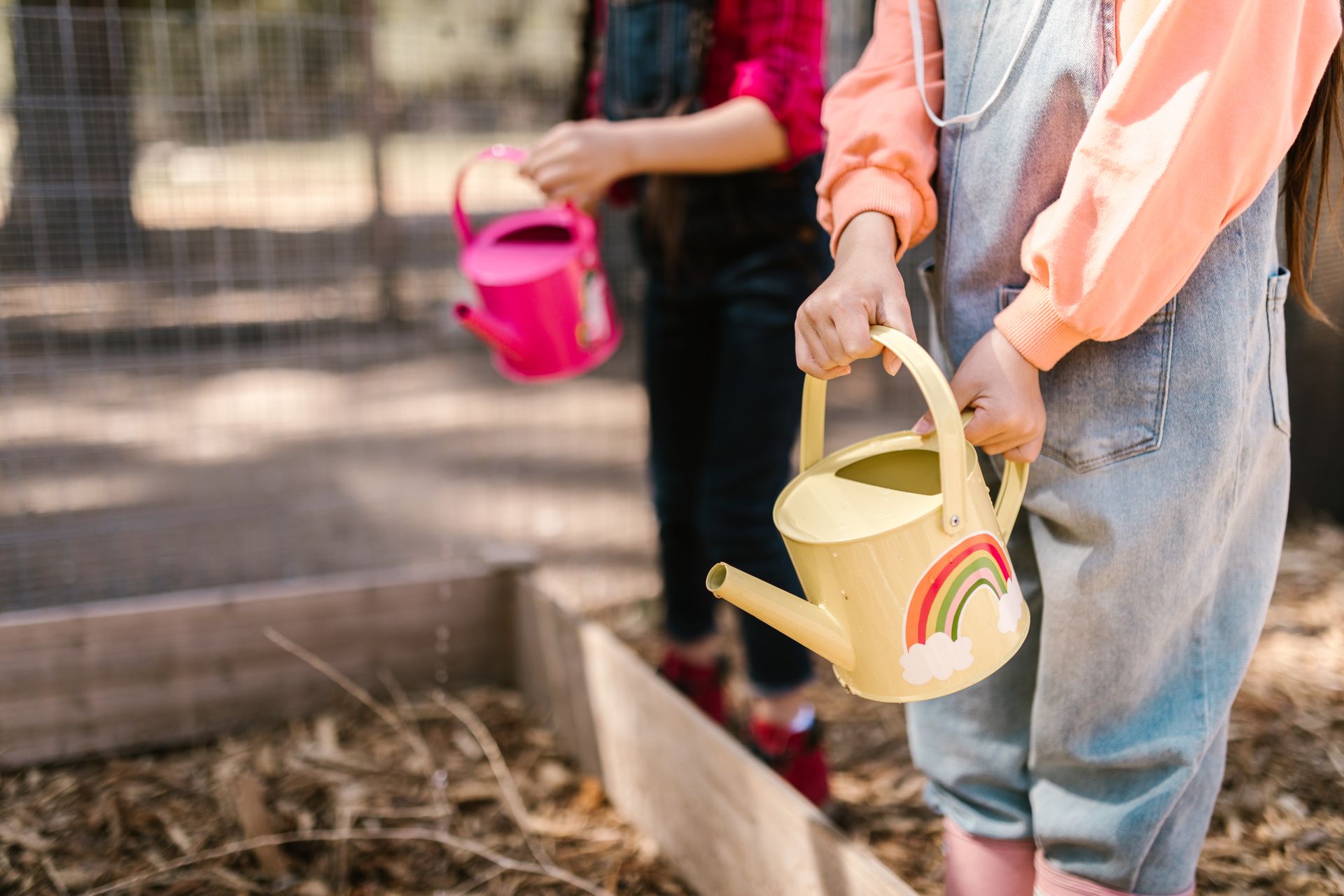 Children using watering cans during an outdoor gardening activity